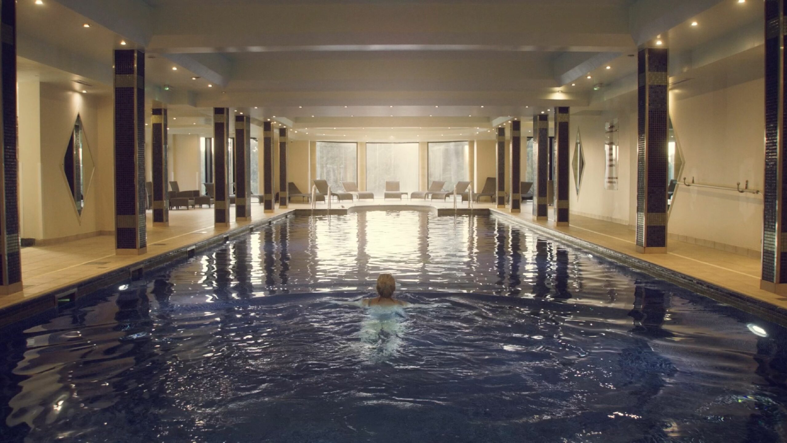 Woman swimming in dimly lit spa pool